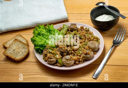 Risoni Pasta - Linsen und Kichererbsen mit Pilzen, knusprig gebratene Zucchini und Salat Stockfoto