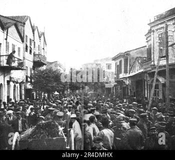 „Les Premiers Contingents Franco-Anglais a Salonique; L'Animation dans la rue du Vardar a Salonique, Apres le defile des troupes francaises. De nombreux soldats grecsse sont meles a la foule', 1915 (1924). Aus „L'Album de la Guerre 1914-1919, Volume I“ [L'Illustration, Paris, 1924]. Stockfoto