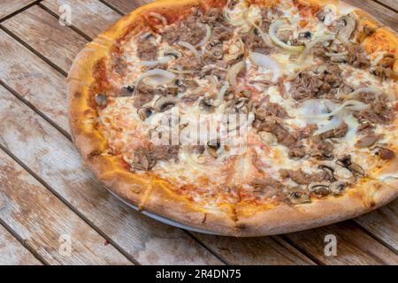 österreich, wien - 10. Mai 2023 Pizza mit Thunfisch, Zwiebeln und Pilzen Pizza auf Holztisch Stockfoto