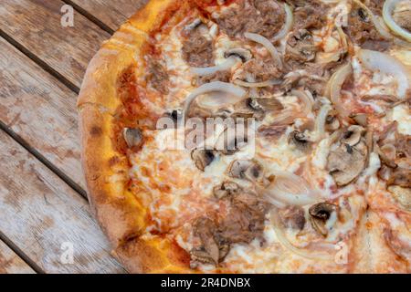 österreich, wien - 10. Mai 2023 Pizza mit Thunfisch, Zwiebeln und Pilzen Pizza auf Holztisch Stockfoto