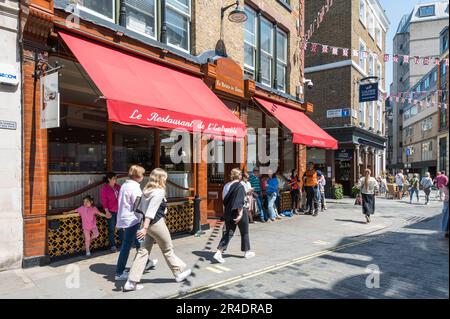 An einem sonnigen frühen Sommertag kommen Besucher am französischen Restaurant Le Relais de Venise L'Entrecote vorbei. Marylebone Lane, London, England, Großbritannien Stockfoto