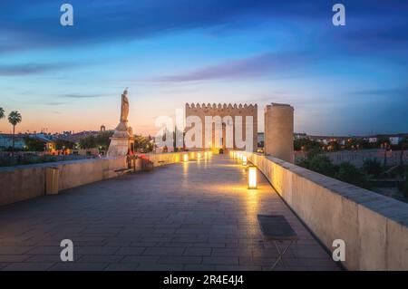 Beleuchtete römische Brücke von Cordoba bei Sonnenaufgang mit San Rafael Statue und Calahorra Tower - Cordoba, Andalusien, Spanien Stockfoto