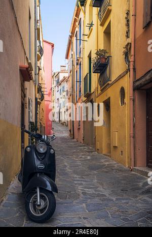 Alte schmale Allee mit einem Motorrad in Collioure, Frankreich Stockfoto