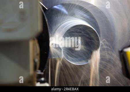 Bearbeitungsrohr auf Drehmaschine. Nahaufnahme. Wasserkühlung des Werkzeugs Stockfoto