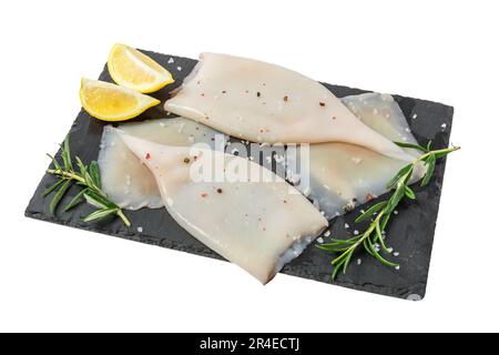 Frisches rohes Tintenfischfilet mit Zutaten zum Kochen auf blak Schieferbrett isoliert Stockfoto