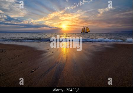 Ein Schiff Segelboot segelt entlang des Ozeans mit Einer Welle bricht an der Küste Stockfoto