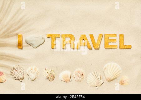 I Love Travel - Inschrift im weißen Sand mit goldenen Buchstaben Stockfoto