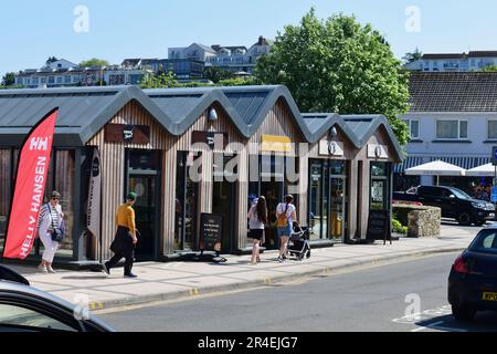 Eine Reihe moderner kleiner Geschäfte im Stadtzentrum von Saundersfoot mit einer großen Auswahl an Bewohnern von Bekleidungsgeschäften bis hin zu Fast-Food-Geschäften. Stockfoto