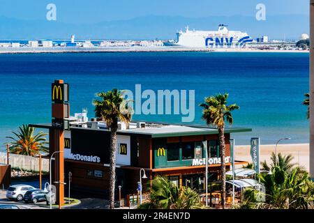 McDonald's Drive-Thru. Im Hintergrund der Grenzzaun und der Hafen von Nador, Marokko. Melilla, Ciudad Autónoma de Melilla, Spanien, África, EU Stockfoto