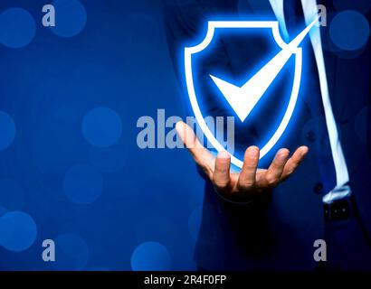 Sicherheitssystem zur Betrugsbekämpfung. Mann mit einem Häkchen in Schild auf blauem Hintergrund, Nahaufnahme. Platz für Text Stockfoto