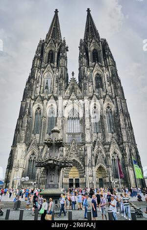 Touristen umgeben den herrlichen gotischen Kölner Dom und seine zwei Türme. Historisches Wahrzeichen Europas. Stockfoto