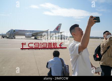 Schanghai. 28. Mai 2023. Passagiere machen Fotos mit einem C919, Chinas selbst entwickeltem großen Passagierflugzeug, bevor ihr erster kommerzieller Flug im ostchinesischen Shanghai am 28. Mai 2023, C919 seinen ersten kommerziellen Flug von Shanghai nach Peking am Sonntag startete, womit ihr offizieller Eintritt in den zivilen Flugzeugmarkt markiert wurde. Kredit: Ding Ting/Xinhua/Alamy Live News Stockfoto