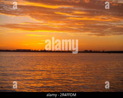 Auswirkung des brillanten Sonnenaufgangs am Morgen über dem Hafen von Tauranga. Stockfoto