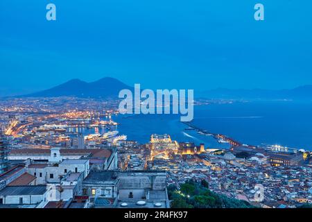 Blick aus der Vogelperspektive auf Neapel bei Nacht vom Vomero-Viertel. Castel Sant'elmo im Vordergrund, während im Hintergrund der Hafen der Stadt und das Schloss Ovo. T Stockfoto