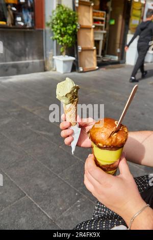 Eiskegel mit Minzpistazienfarbe in der Stadt. Sommerliche kalte Erfrischung. Köstliches Essen. Stockfoto