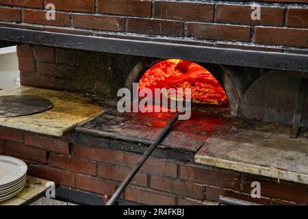 Gebackene leckere Margherita Pizza im traditionellen Holzofen, in Neapel, Italien. Original neapolitanische Pizza. Red Hot Kohle. Stockfoto