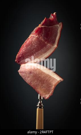 Trocken ausgehärtetes Schweinefilet auf schwarzem Hintergrund. Stockfoto