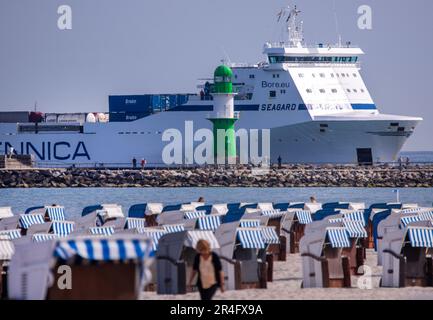 Rostock, Deutschland. 28. Mai 2023. Die finnische Fähre „Seagard“ fährt von Kotka (Finnland) in den Hafen, während die meisten Liegen an der Ostseeküste morgens noch leer sind. Mit viel Sonnenschein und hohen Temperaturen zeigt das Wetter seine beste Seite in Norddeutschland am Pfingstsonntag. Kredit: Jens Büttner/dpa/Alamy Live News Stockfoto