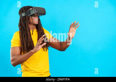 Ein glücklicher latino mit Dreadlocks, der eine Virtual-Reality-Brille trägt Stockfoto