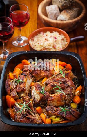 Gebratener Schweinebauch auf Gemüse mit Sauerkraut und Rotwein Stockfoto