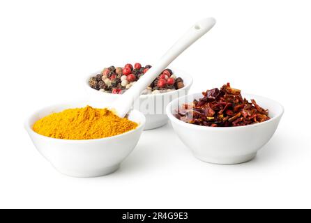 Gewürze Curry, Paprika Mix und Paprika in Keramikschüssel auf weißem Hintergrund Stockfoto