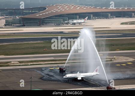 Shanghai, China. 28. Mai 2023. Ein C919 großes Passagierflugzeug, Chinas erster selbst entwickelter Rumpf-Jet, wird nach der Landung am Peking Capital International Airport in Peking, Hauptstadt von China, am 28. Mai 2023 mit einem Wassersalut begrüßt. Der C919, Chinas selbst entwickeltes großes Passagierflugzeug, schloss seinen ersten kommerziellen Flug von Shanghai nach Peking am Sonntag ab und markierte damit seinen offiziellen Eintritt in den zivilen Luftverkehr. Kredit: Wang Yang/Xinhua/Alamy Live News Stockfoto