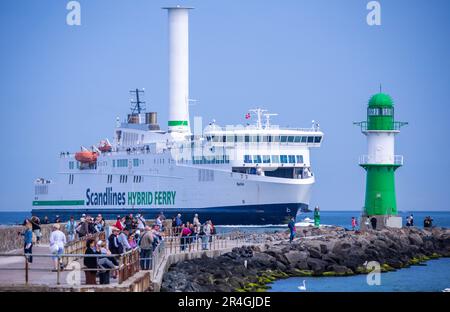 Rostock, Deutschland. 28. Mai 2023. Urlauber und Tagesbesucher beobachten vom Pier aus die Ankunft der Fähre „Berlin“ aus Dänemark am Meereskanal in Warnemünde. Mit viel Sonnenschein und warmen Temperaturen zeigt das Wetter am Pfingstsonntag in Norddeutschland seine beste Seite. Kredit: Jens Büttner/dpa/Alamy Live News Stockfoto