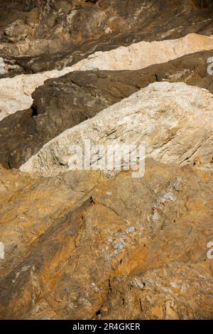 Ockerfarbene Steine bilden eine Art Welle, wenn sie so platziert werden, dass ihre Farben diese optische Täuschung erzeugen. Stockfoto