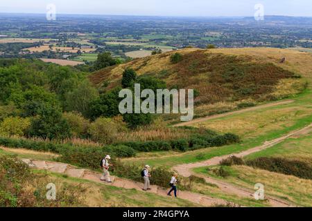 Drei Wanderer steigen vom Millennium Hill auf den Malvern Hills, Worcestershire, England, Großbritannien ab Stockfoto