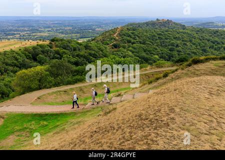 Drei Wanderer steigen vom Millennium Hill auf den Malvern Hills, Worcestershire, England, Großbritannien ab Stockfoto