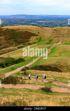 Drei Wanderer steigen vom Millennium Hill auf den Malvern Hills, Worcestershire, England, Großbritannien ab Stockfoto