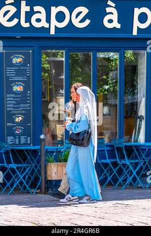 Zwei junge Frauen gehen durch das Stadtzentrum / auf Arabisch in traditioneller Kleidung - Tours, Indre-et-Loire (37), Frankreich. Stockfoto