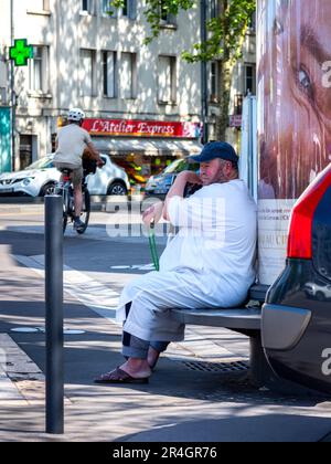 Aram Mann in weißer Kleidung sitzt auf der Bank im Stadtzentrum - Tours, Indre-et-Loire (37), Frankreich. Stockfoto