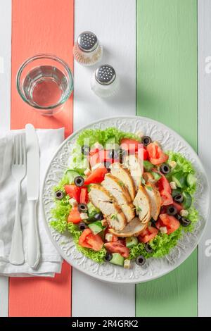 Leckerer und hausgemachter Caesar-Salat mit Tomaten, Oliven und Salat. Klassischer Hühnersalat. Stockfoto