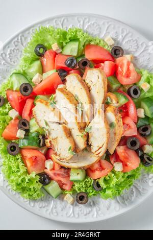Gesunder und klassischer Caesar-Salat mit Hühnchen, Salat und Tomaten. Traditioneller Caesar-Salat. Stockfoto