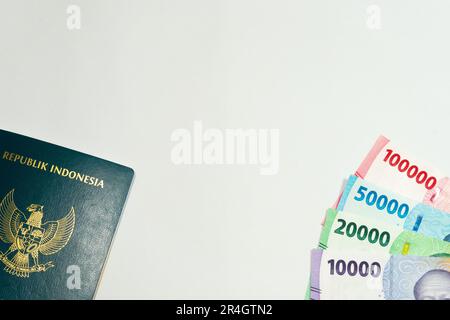 Indonesischer Pass und 10000-, 20000-, 50000- und 100000-Rupiah-Währungsgeld auf weißem Hintergrund Stockfoto