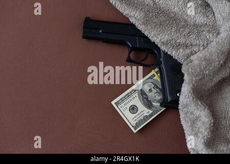 Handfeuerwaffe auf dem US-Dollar-Stapel - kriminelles Geldkonzept Stockfoto