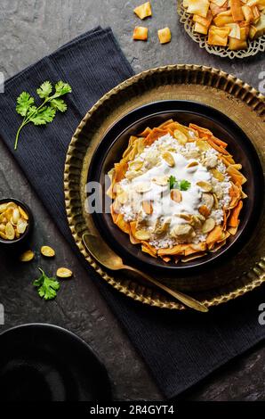 Arabische Küche: Jordanisches Hähnchen „Mansaf“ aus weißem Reis und knuspriges gebratenes Brot garniert mit Hähnchenstücken und Knoblauchjoghurtsauce. Stockfoto