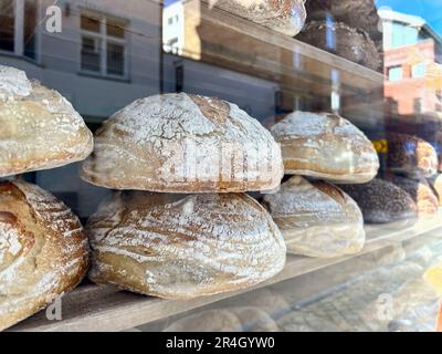Brot, Blick aus der Nähe, köstliches Brot im Schaufensterladen der Bäckerei mit Straßenreflexion. Fenster für Bäckerei. Hintergrundkonzept für Lebensmittel Stockfoto