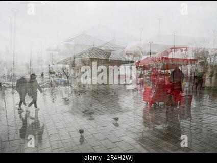 An einem Regentag bewegen sich Menschen auf dem Uskudar-Platz. Mehrfachbelichtung. Istanbul, TÜRKEI Stockfoto