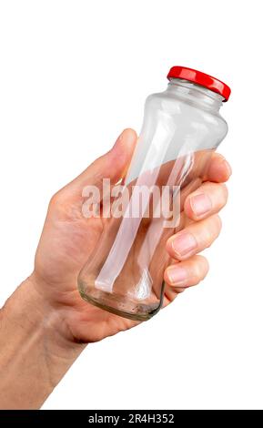 Halten Sie den leeren Glasbehälter mit der Hand fest, der mit einem roten Verschluss auf weißem Hintergrund verschlossen ist. Stockfoto