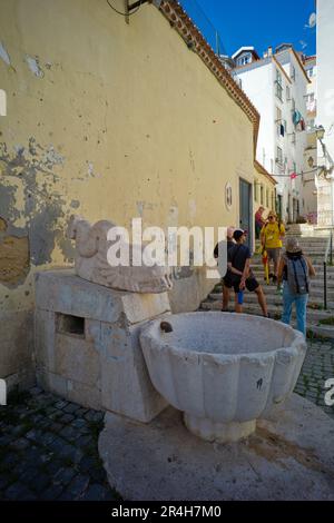 Ein Reiseleiter mit Touristen im Alfama-Viertel von Lissabon, wo Alt auf Neu trifft Stockfoto