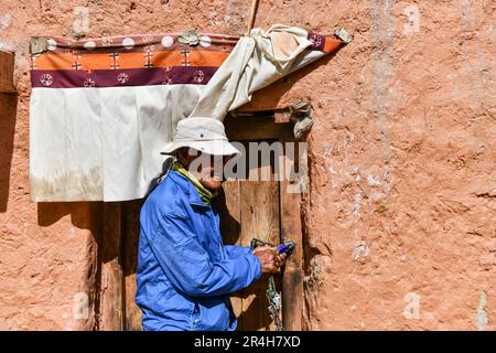 (230528) -- ZANDA, 28. Mai 2023 (Xinhua) -- Rigzin Wangzhab öffnet die Tür einer Grotte im Bezirk Zanda der Präfektur Ngari, Autonome Region Tibet im Südwesten Chinas, 26. Mai 2023. Versteckt zwischen Sandsteinhügeln im abgelegenen Westen Tibets liegt ein Abschnitt von honigwabenförmigen Höhlen weit außerhalb der Reichweite der meisten Reisenden. Die 1.000 Jahre alten Höhlen in der Präfektur Ngari in der Autonomen Region Tibet, die als Donggar- und Piyang-Grotten bekannt sind, beherbergen eine der weltweit größten Sammlungen tibetischer buddhistischer Wandbilder. Rigzin Wangzhab, 75, bewacht das Gelände seit über 20 Jahren. Wenn ich es war Stockfoto