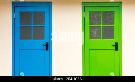 Reihe von bunten alten hölzernen ändern Schaltkastentüren in Grundfarben mit quadratischen Fensterscheiben North Berwick Hafen, East Lothian, Schottland, Großbritannien Stockfoto