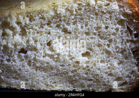 Eine Scheibe Roggenbrot mit knuspriger Kruste und Textur im Loch. Frisches, hausgemachtes Sauerteigbrot. Foto in hoher Qualität Stockfoto