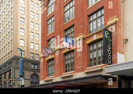 San Antonio, Texas, USA – 9. Mai 2023: Altes rotes Backsteingebäude mit Flaggen der USA und Texas im Zentrum von San Antonio, Texas Stockfoto