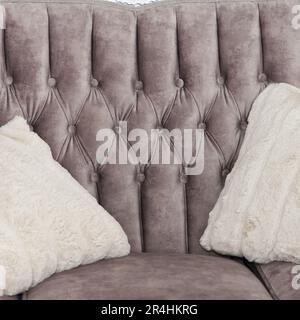 Schönes, komfortables graues Sofa mit weichen, hellgrauen Kissen, Teil der Inneneinrichtung im Wohnzimmer, Schrank. Konzentrier dich auf das Sofa Stockfoto