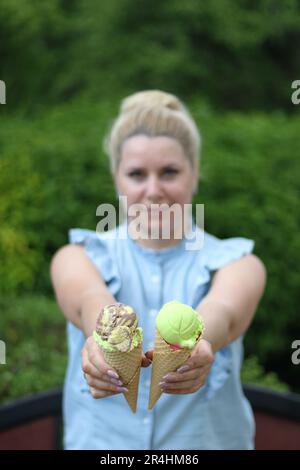 Eine Frau hält ein Eis in beiden Händen. Konzentrier dich auf das Eis. Nahaufnahme. Stockfoto