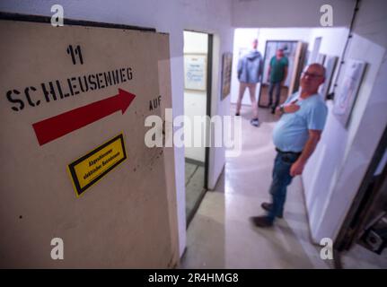 28. Mai 2023, Mecklenburg-Vorpommern, Zürow: Besucher besichtigen einen ehemaligen DDR-Bunker und sehen die Ausstellung mit einer Sammlung von DDR-Einkaufstaschen. Collector Luchs, 83, stellt insgesamt 120 Plastiktüten in der unterirdischen Betonstruktur in einem Wald bei Wismar aus. Seit Jahrzehnten sammelt der ausgebildete Schreibmaschinenleser die Taschen mit Motiven von FDJ-Treffen, der DDR Volkspolizei oder Werbegrafiken für ostdeutsche Unternehmen und wird einen Teil seiner Sammlung interessierten Besuchern im 140 Quadratmeter großen Bunker am Pfingstsonntag präsentieren. Das Bunkergebäude von t Stockfoto