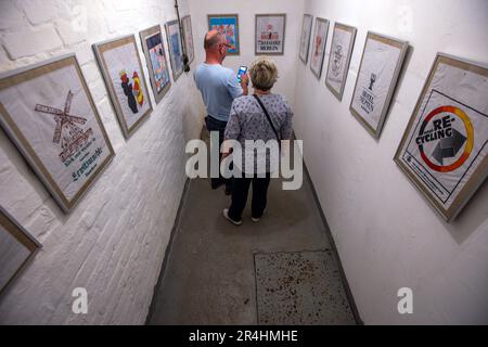 28. Mai 2023, Mecklenburg-Vorpommern, Zürow: Besucher besichtigen einen ehemaligen DDR-Bunker und sehen die Ausstellung mit einer Sammlung von DDR-Einkaufstaschen. Collector Luchs, 83, stellt insgesamt 120 Plastiktüten in der unterirdischen Betonstruktur in einem Wald bei Wismar aus. Seit Jahrzehnten sammelt der ausgebildete Schreibmaschinenleser die Taschen mit Motiven von FDJ-Treffen, der DDR Volkspolizei oder Werbegrafiken für ostdeutsche Unternehmen und wird einen Teil seiner Sammlung interessierten Besuchern im 140 Quadratmeter großen Bunker am Pfingstsonntag präsentieren. Das Bunkergebäude von t Stockfoto